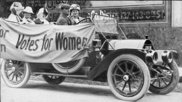 Members of the Political Equality League in an early Ford automobile draped with bunting reading "Votes for Women." In the front seat is Mrs. B.C. Gudden. In the back seat, left to right, are Ruth Fitch, Bertha Pratt King, and Helen Mann.