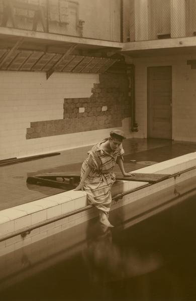 Esther Eloise McGilvra, member of the Menomonie High School class of 1905, depicted as a swimmer, next to a wooden diving board. Part of a yearbook created by classmate Albert Hansen, based on a class prophecy theme.