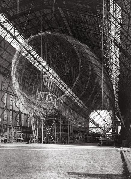 The frame of the Graf Zeppelin being built, surrounded by scaffolding in a hangar in Friedrichshafen, Germany.