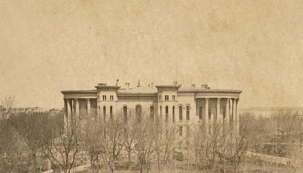 The Third Wisconsin State Capitol before the completion of the dome.  After all four wings of the Third Capitol were completed, the second Capitol was demolished and the central portion of the third constructed over its foundations to connect the wings. A disagreement over the plan for the dome designed by August Kutzboch and Samuel H. Donnel halted construction and left the new building topless. The dome was finally constructed in 1869 with a new classical design by Stephen V. Shipman.  Local tradition has it that the rejection of his design may have contributed to Kutzbock's suicide in 1868.