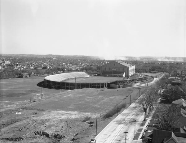 Elevated view of Camp Randall Stadium and Field House with landscape behind.
