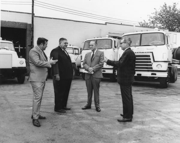 Following delivery of 95 International trucks to Redwing Carriers, Inc., two International truck salesmen pose with Redwing executives on dealership grounds. Pictured (from left to right) are: H.G. Hilton, Tampa branch sales manager; A.T. Sanchez, Redwing president; Franck Cochran, Tampa fleet salesman; and E.W. Bornwell, Redwing's superintendent of maintenance for all southern operations.