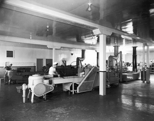 Man working with machinery at the Red Dot Potato Chip plant.