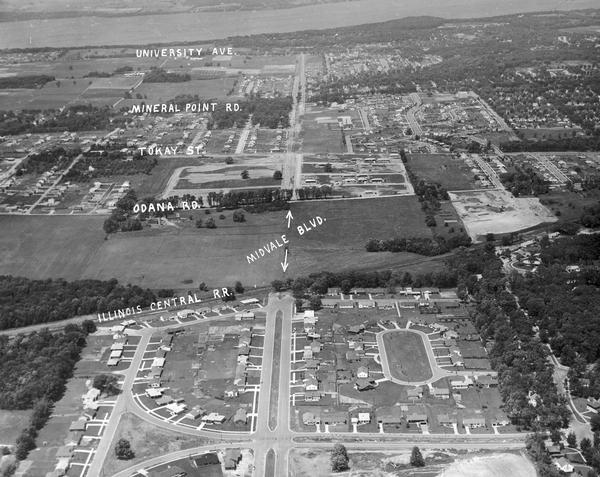 Aerial view looking north from near the city's southwestern limits in 1954. Shows text indicating Midvale Boulevard, Odana Road, Tokay Boulevard, Mineral Point Road, and University Avenue with Lake Mendota in the distance.
