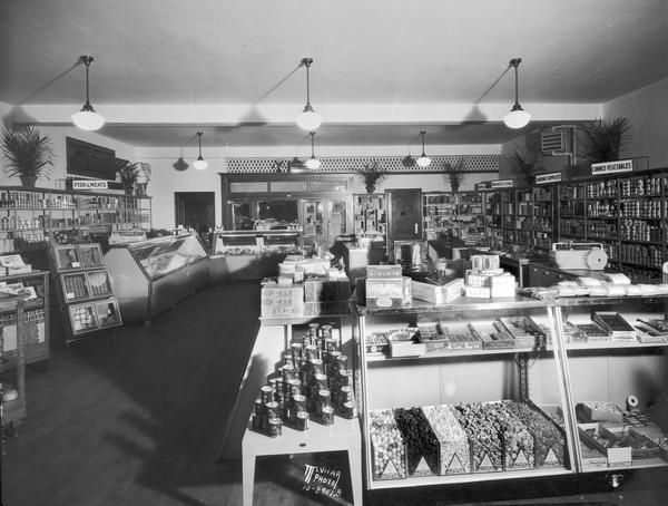 Interior view of Sweet's Food Shop at 427 (or 445) West Main Street, with display cases of candy and shelves stocked with food items. 
