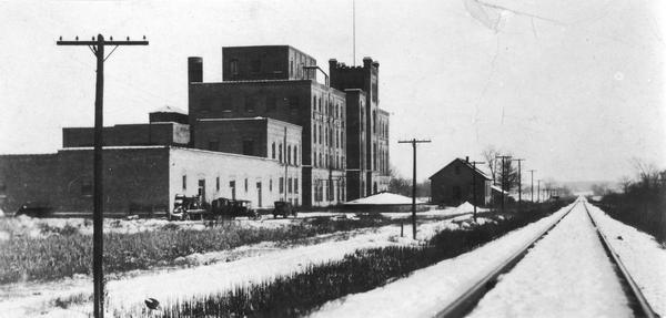 Exterior view of the United States Sugar Company factory next to railroad tracks on Atwood Avenue. The building was occupied in 1980 by Garver Feed & Supply.