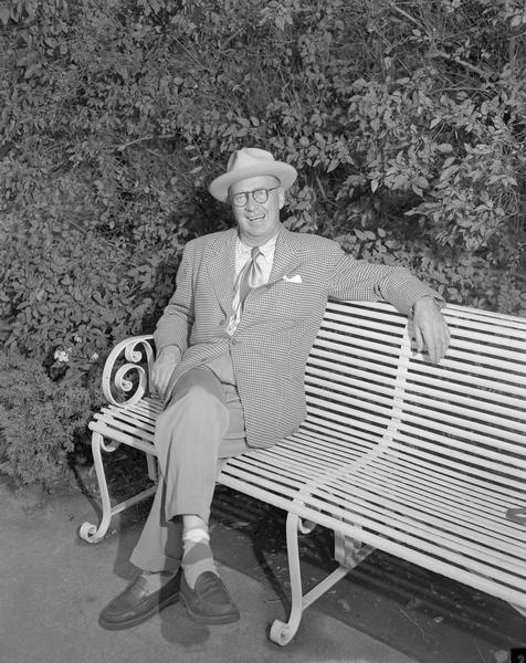 <i>Wisconsin State Journal</i> sports columnist, Joseph L. "Roundy" Coughlin and "character about town" relaxes on a park bench.