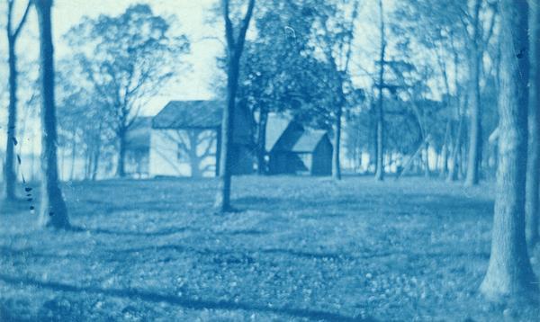 Cyanotype print of Winnequah on Lake Monona with small buildings and three platforms for swings. A note on the back of the print reads: "The high swing was a great attraction and the take-off from the platforms a thriller."