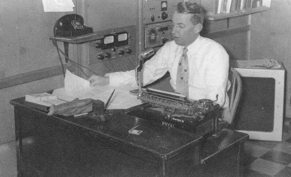Radio operator Hilding Foreen at a desk broadcasting for WHRM.