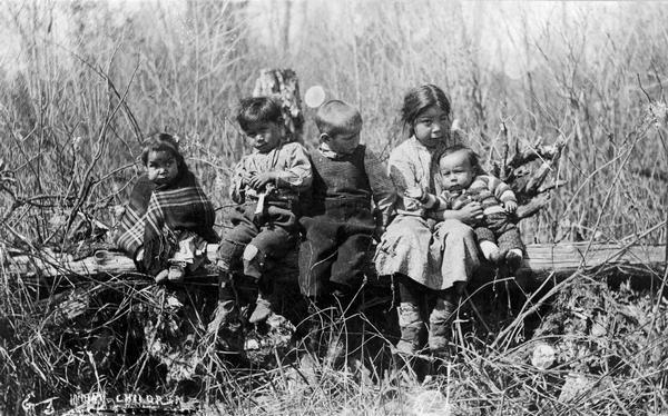 A group of five Menominee children, thought to be photographed on the Menominee Reservation in Wisconsin. This image is part of an exhibit about Native Americans prepared by Paul Vanderbilt, the Wisconsin Historical Society's first curator of photography. Caption reads: "Indian Children."