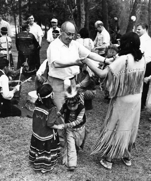 Wisconsin State Senator Alfred A. Laun (R.) of Kiel, participating in what appears to be a square dance with Menominee Indians and others. This image is part of an exhibit about Native Americans prepared by Paul Vanderbilt, the Wisconsin Historical Society's first curator of photography.