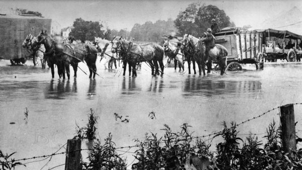The Great Wallace Shows, horses and wagons, were flooded out by a sudden cloudburst.