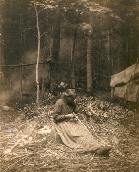 A Chippewa (Ojibwa) woman preparing splints for basket making. This image is part of an exhibit about Native Americans prepared by Paul Vanderbilt, the first curator of photography at the Wisconsin Historical Society.