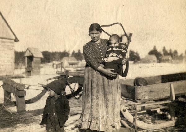 A Chippewa (Ojibwa) mother with two children, one of whom is in a cradleboard, at the Lac du Flambeau reservation. This image is part of an exhibit about Native Americans prepared by Paul Vanderbilt, the first curator of photography at the Wisconsin Historical Society.