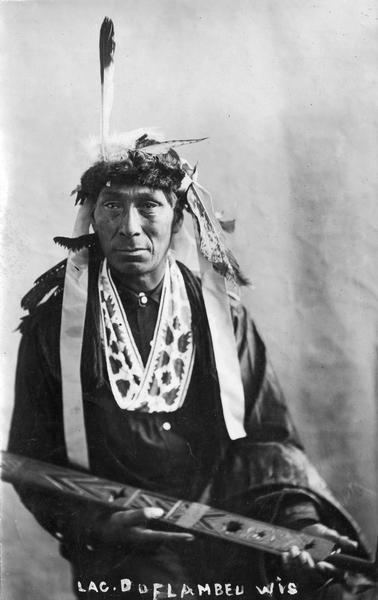 A postcard of a Native American (Ojibwa) at Lac du Flambeau, Wisconsin. This image is part of an exhibit about Native Americans prepared by Paul Vanderbilt, the first curator of photography at the Wisconsin Historical Society. Caption reads: "Lac du Flambeau, Wis."
