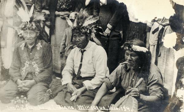Indians playing a game at Lac du Flambeau, Wisconsin. "The man in the center is holding counting sticks. A constant drumming is kept up to make concentration a sporting proposition." This image is part of an exhibit about Native Americans prepared by Paul Vanderbilt, the first curator of photography at the Wisconsin Historical Society.