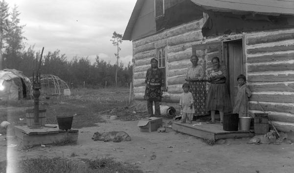 Medicine man John King, his wife, grandchild, and family on the Lake Courte Oreilles Chippewa reservation near Couderay.