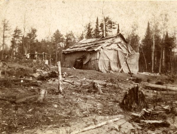 A cabin at Clear Lake (Vilas County), a small Chippewa (Ojibwa) settlement, occupied by a white man and his Native American wife. This image is part of an exhibit about Native Americans prepared by Paul Vanderbilt, the first curator of photography at the Wisconsin Historical Society.