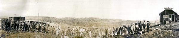 Panoramic group portrait of workers, who are building the Penisular Power Company, located on the Brule River.