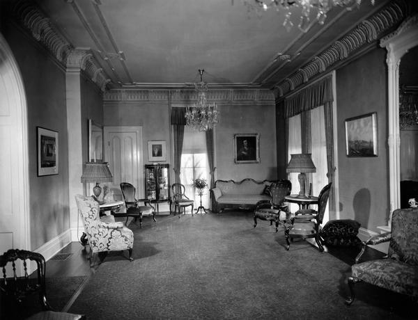 Interior photograph of the reception room at the former Wisconsin Governor's Mansion on Gilman Street. The painting above the sofa, which belonged to Governor Walter J. Kohler, Sr., helps to date the photograph.