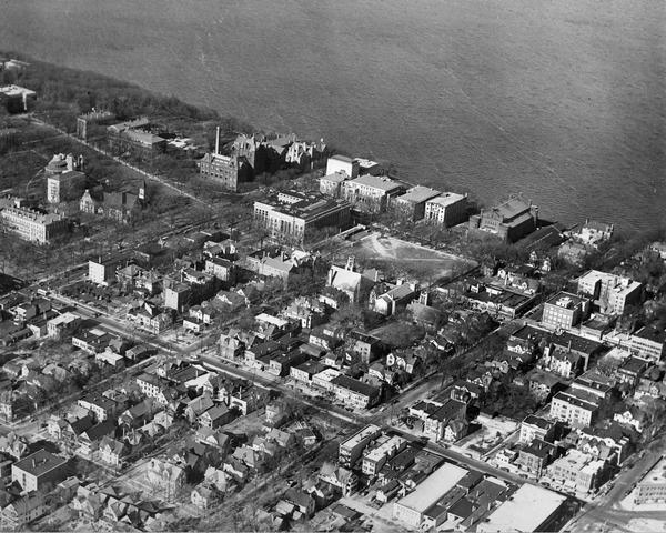 View of the lower campus of the University of Wisconsin-Madison includes Bascom Hill, Wisconsin Historical Society, Memorial Union and the Armory (Red Gym or Old Red), student rooming house district and city streets with Lake Mendota in the background.