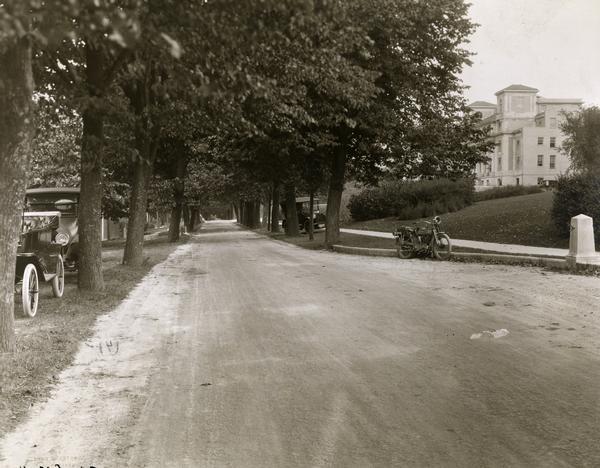 View of tree-lined Linden Drive includes parked motorcycles and automobiles on the University of Wisconsin campus.