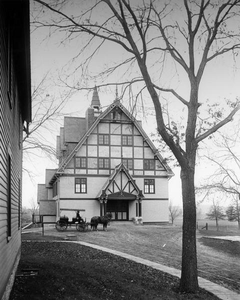 View of the Horse Barn at the College of Agriculture with a horse and buggy on the University of Wisconsin campus.