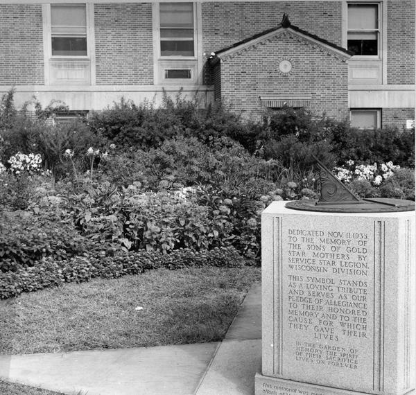 View of the sun dial with the exterior of the  College of Agriculture.