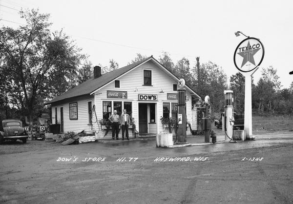 Two men pose outside Dow's store and filling station on Highway 77.