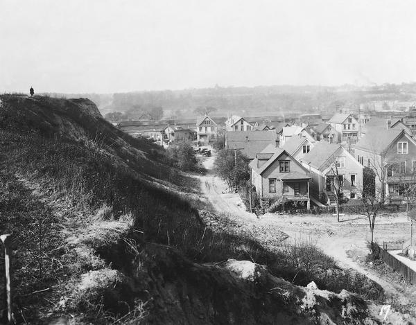 Elevated view from a hill of an alley connecting Park Hill Avenue and Mount Vernon Avenue, looking west from the Interurban Line. There is a person on top of the hill. Text at foot of photograph reads, "Alley Between Park Hill Ave. & Mt. Vernon Ave. 20+02 Looking West from Line." The number "17" appears in the lower right corner.