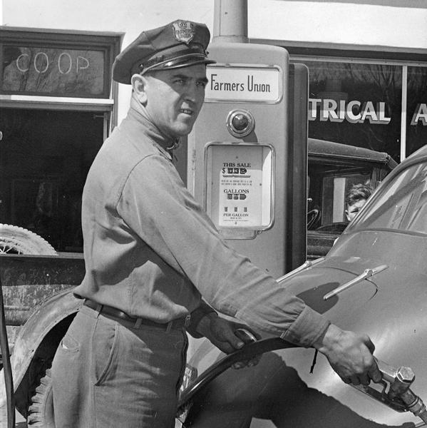 Service station manager Lyndon Ellefson of the local cooperative gasoline station pumps gasoline into the tank of a car.