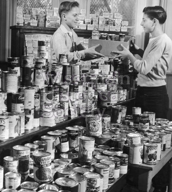 Thomas Constable (left) and Walter Medenski (right), pose in front of canned food gathered by pupils at the Center Street school for the Salvation Army's Thanksgiving food drive.