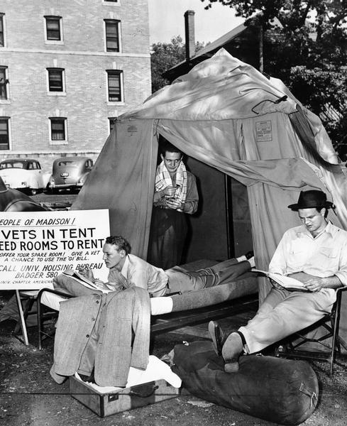 Three men at the University of Wisconsin, with tent and sign that reads "People of Madison! Vets in tent need rooms to rent".