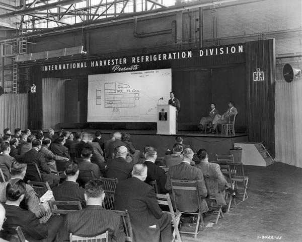 Executive giving speech to assembly of branch managers as part of "Harvester Plans for the Future Week" at International Harvester's Evansville Works (factory), October 7-11, 1946. The Evansville Works produced refrigerators, freezers and air conditioners.