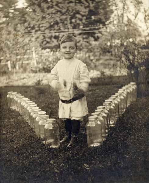 Warren Fenn Bodurtha Gardner, almost 5, poses with empty Horlick's Malted Milk bottles in appreciation to Horlick's. Young Gardner's mother died shortly after he was born, and he couldn't tolerate pure cow's milk. His aunt and grandmothers fed him Horlick's, resulting in the healthy boy pictured here.
