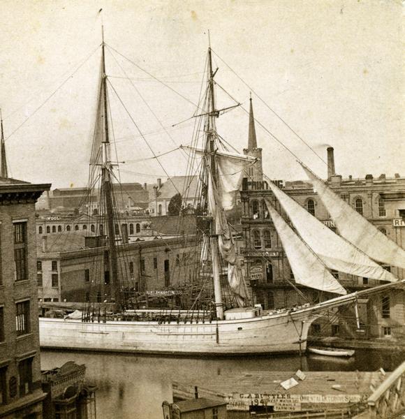 Elevated view of Milwaukee River with large sailing ship - a two-masted schooner - entering the port.