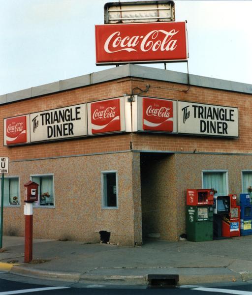 Exterior view of the The Triangle Diner. A large Coca-Cola sign is on top of the diner.