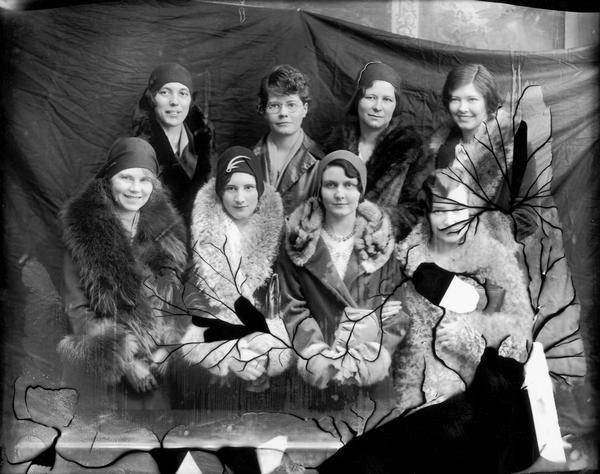 Studio portrait of women who are taking flying lessons. Several of the women are dressed in furs.