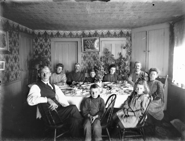 A family poses at the dining room table after dinner in Luther Valley.