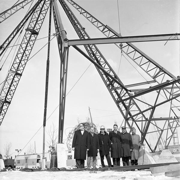 Construction begins of the Wisconsin Rotunda at the New York World's Fair. Principals of the project are standing in a group, and include Michael Pender, William E. Potter, Fred Bloch, Lt. Governor Jack B. Olson, Arlie Mucks, and John Steinmann, architect.