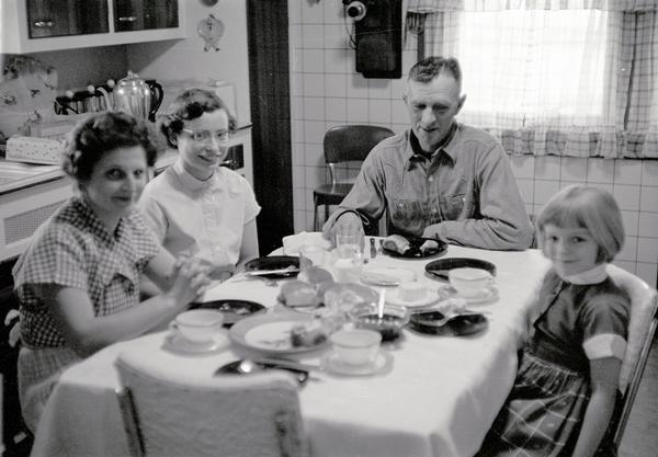 The Kern family, Edna, Nancy, Ernest, and Maribeth, at the supper table.