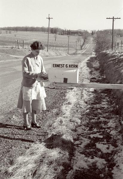 Edna Kern picking up the mail at the roadside mailbox.