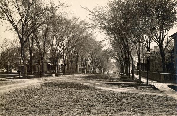 View looking east down 100 block of East Gilman Street, from the intersection of East Gilman and North Pinckney Streets. The Mears House, 116 East Gilman, is on the left. The old Governor's Residence (130 East Gilman Street) is the second home on the left. The hitching post and stone platform on the left side of the street were for the convenience of friends arriving by carriage.