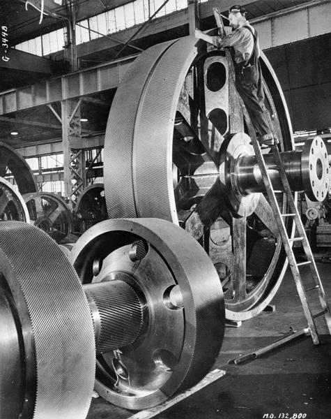 Workman working on the main reduction gears for a Victory Ship at the Falk Corporation, Milwaukee, Wisconsin.