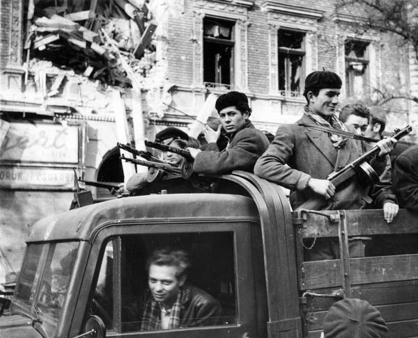A UPI photograph depicting Hungarian "Freedom Fighter" on the streets of Budapest during the Hungarian popular revolt against Soviet occupation.  Note the shell damage to the building in the background.