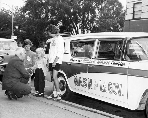 Life on the campaign trail with Philleo Nash, in front of the Philleo Nash Rambler, greeting young supporters. Nash was running as the Democratic candidate for Lieutenant Governor of Wisconsin.
