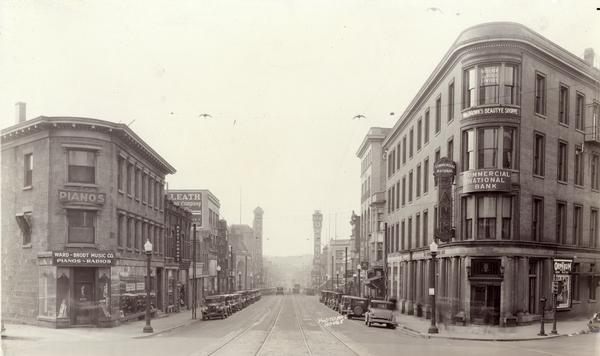 View of State Street looking toward the University of Wisconsin Madison campus from the Wisconsin State Capitol, with marquees for Ward-Brodt Music Co., Leath's Furniture store, New Orpheum Theatre, YWCA, Commercial National Bank, and Mrs. Brown's Beauty Shoppe.