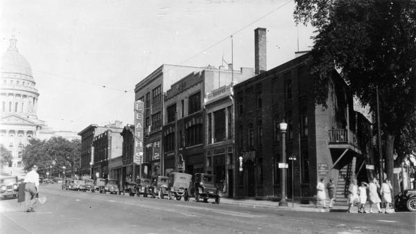 View of 100 Block of State Street, with marquees for Leath's and the Wisconsin State Capitol in the background.