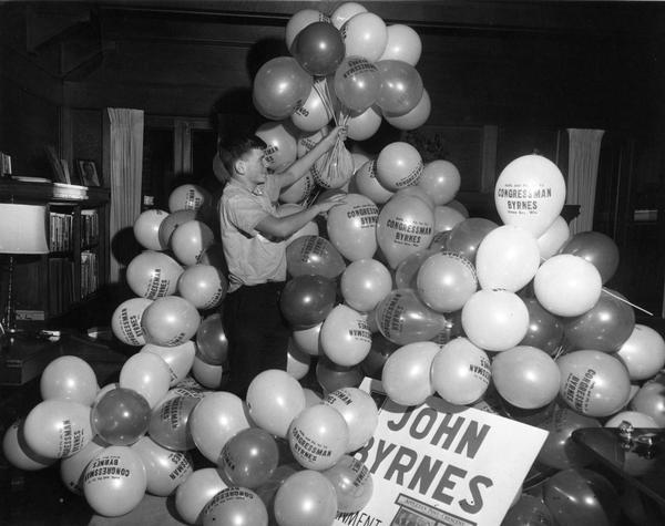 Boy holds up balloons for Congressman Byrnes during his 1962 campaign.
