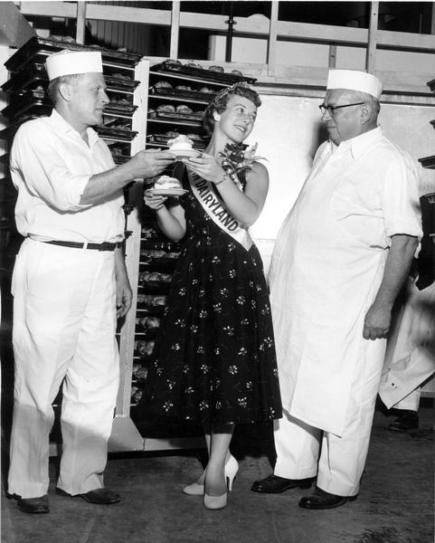 Alice in Dairyland, Doris Olsen, holds a cream puff, always a favorite Wisconsin State Fair treat, as she talks with two bakers at the fair.